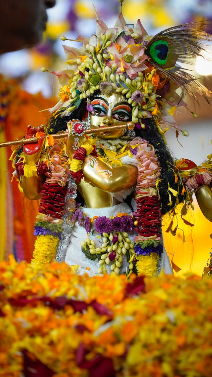 Vibrant Hindu deity statue adorned with flowers, showcasing intricate cultural artistry.