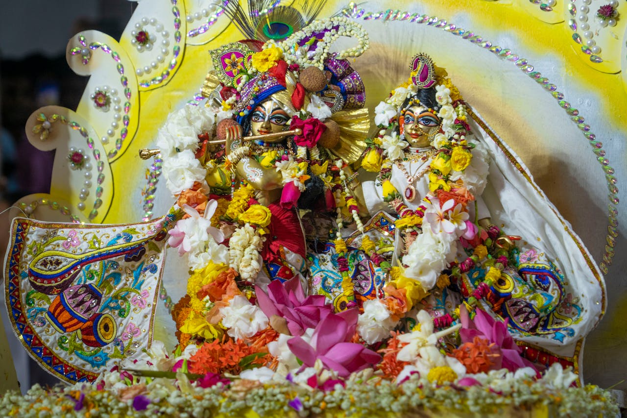 Vibrant Hindu deity statues decorated with colorful flowers and traditional attire.